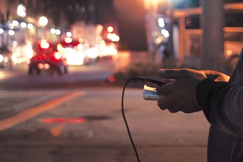 hand holding handphone and wire charger
